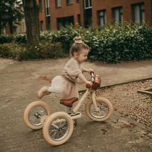 tüdruk sõidab beezi jooksurattaga tänaval